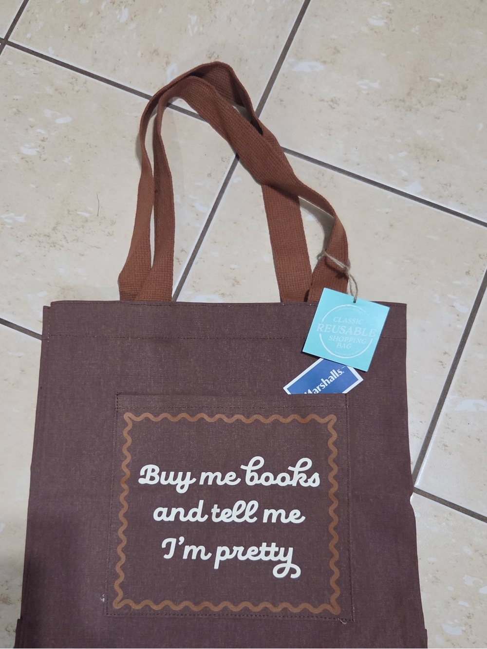 Brown Booked theme tote bag with white text reading 'Buy me books and tell me I'